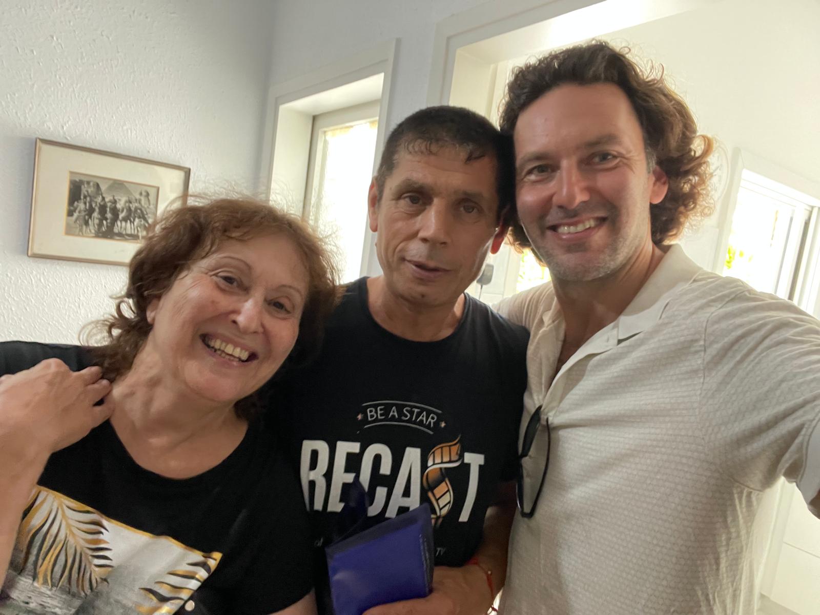 Three people together, with one wearing a Recast T-shirt